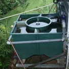 Biologický filter s piatimi komorami ukrytý za záhradným domčekom.