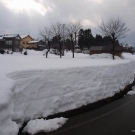 Vyfrézovaná cesta s mantinelmi snehu do výšky 1,8 m.