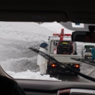 Cestári odpratávajú snehový závej z cesty.